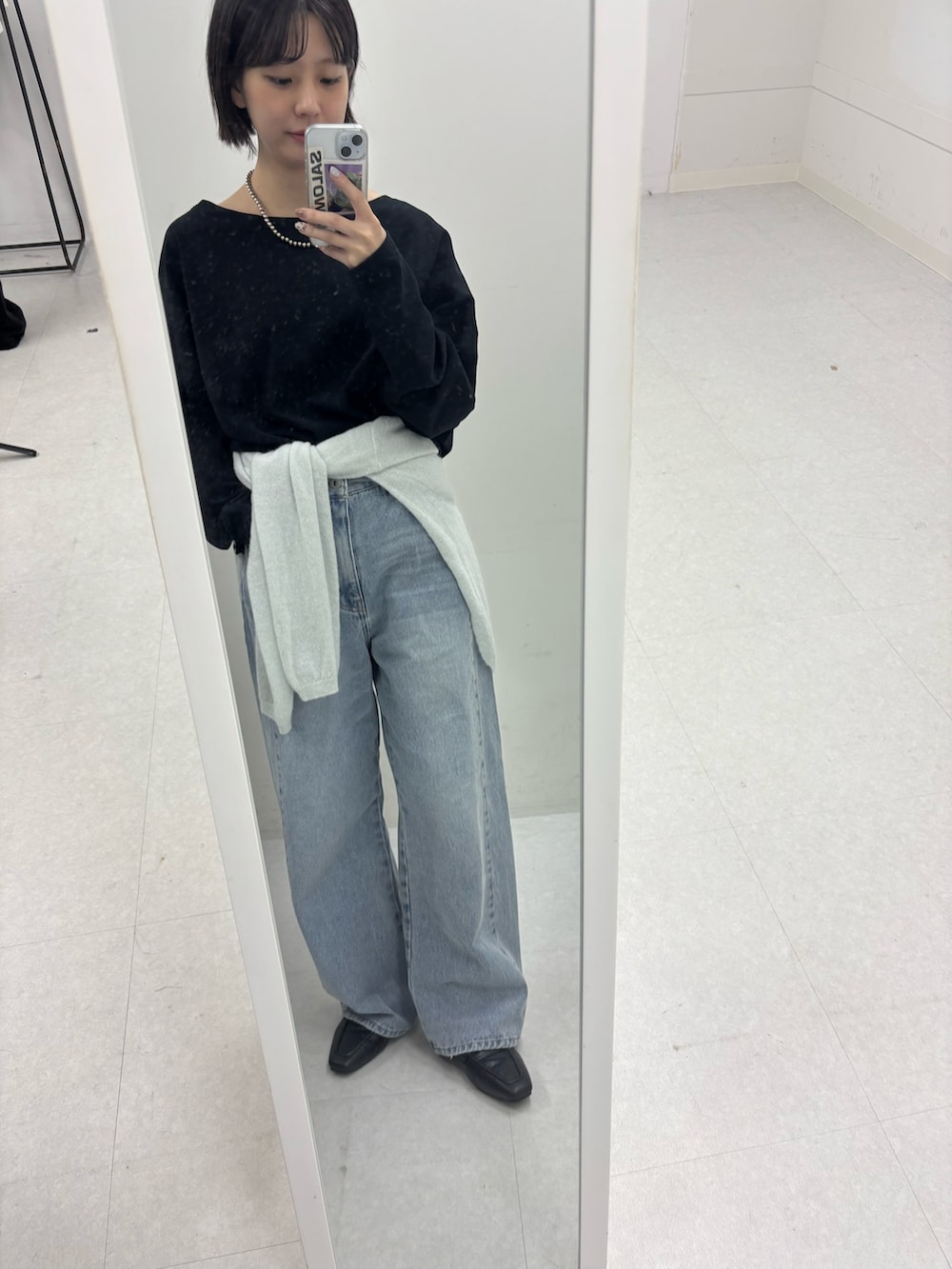 ブルー系のデニムパンツ、グリーン系のニット/セーターを着用したレディースの秋コーディネートの2枚目の写真
