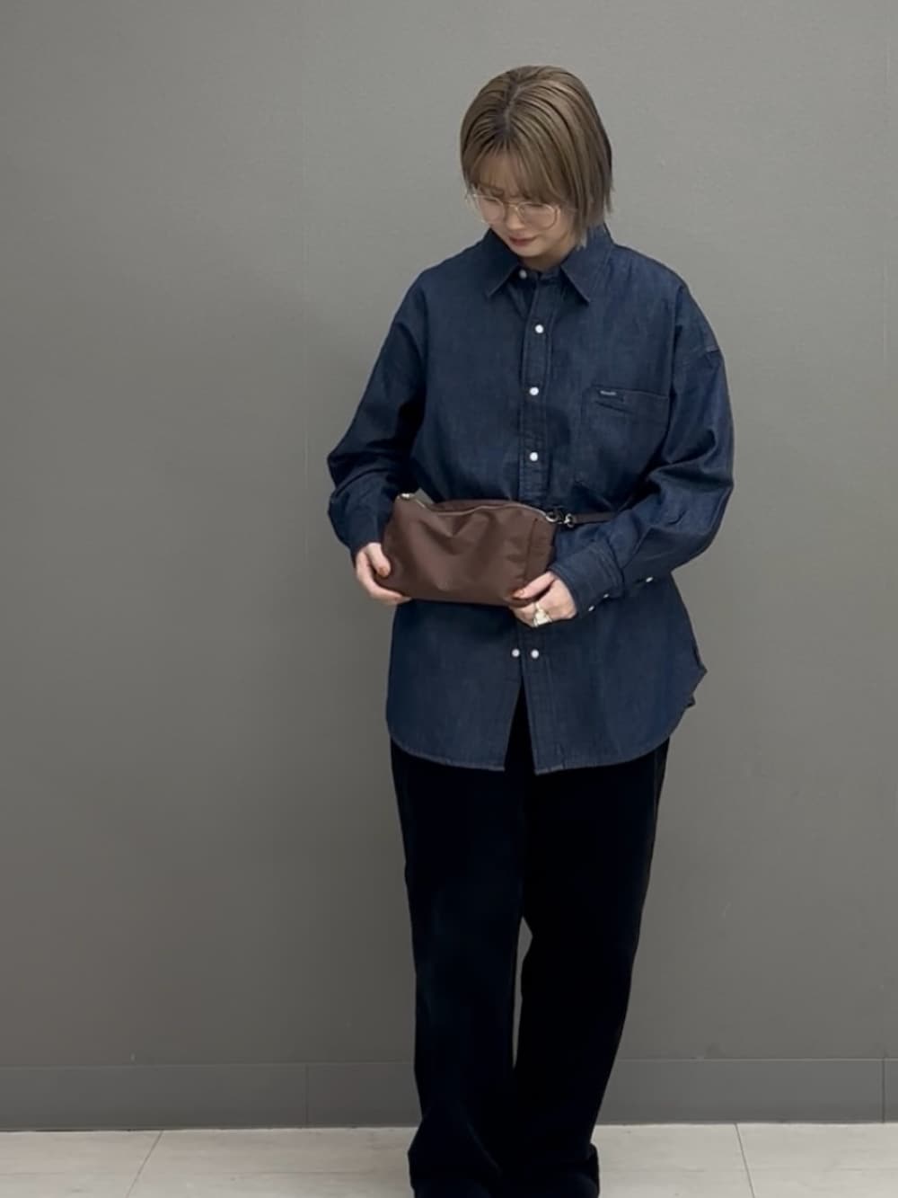 ブラウン系のショルダーバッグ、ブルー系のシャツ/ブラウスを着用したレディースの冬コーディネートの2枚目の写真