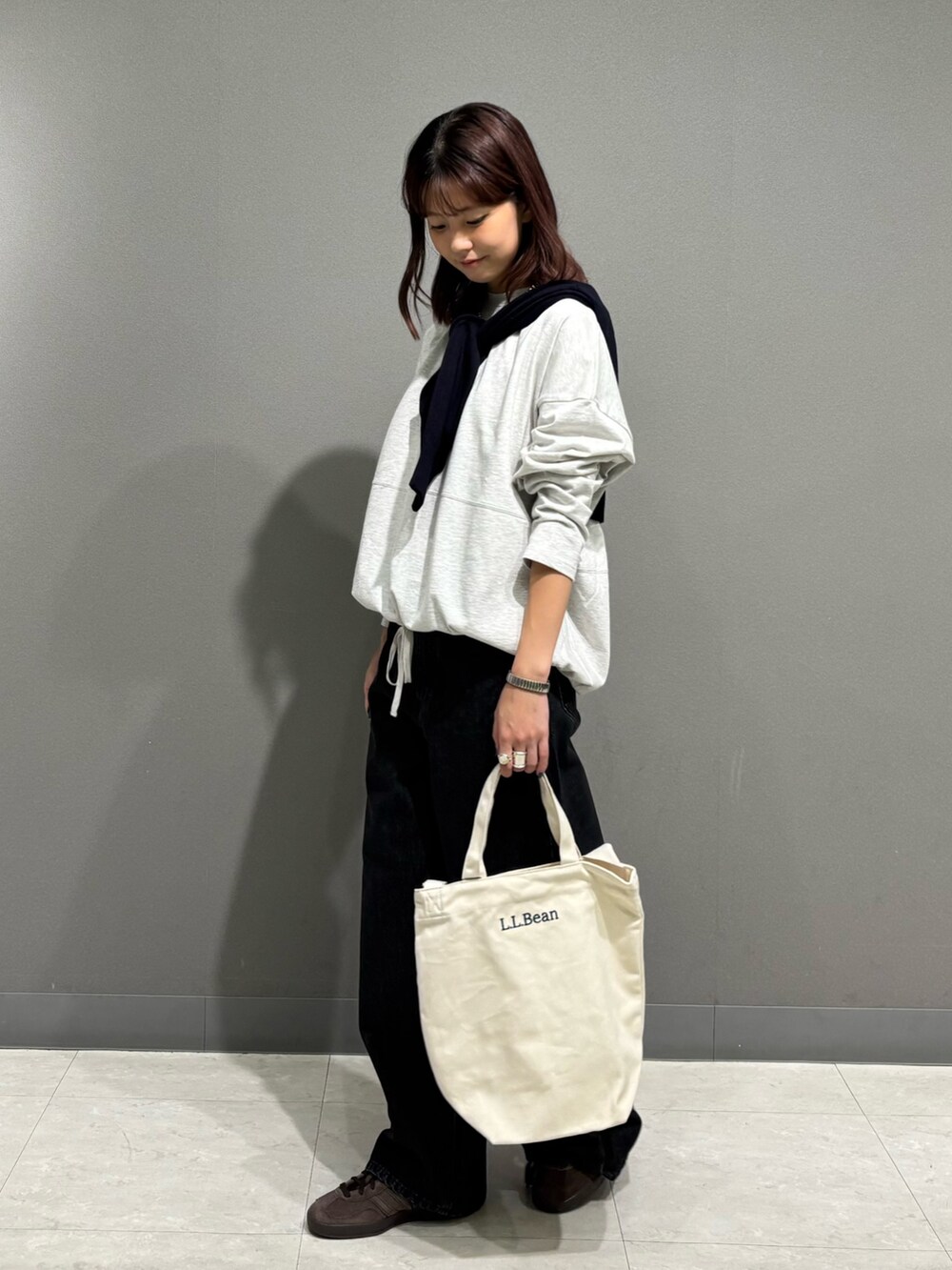 ベージュ系のTシャツ/カットソー、ブルー系のカーディガン/ボレロ、ブラック系のデニムパンツを着用したレディースの秋コーディネートの3枚目の写真