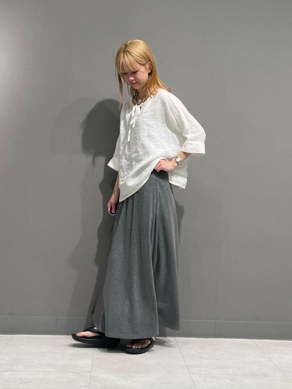 グレー系のスカート、ホワイト系のシャツ/ブラウスを着用したレディースの春コーディネートの6枚目の写真