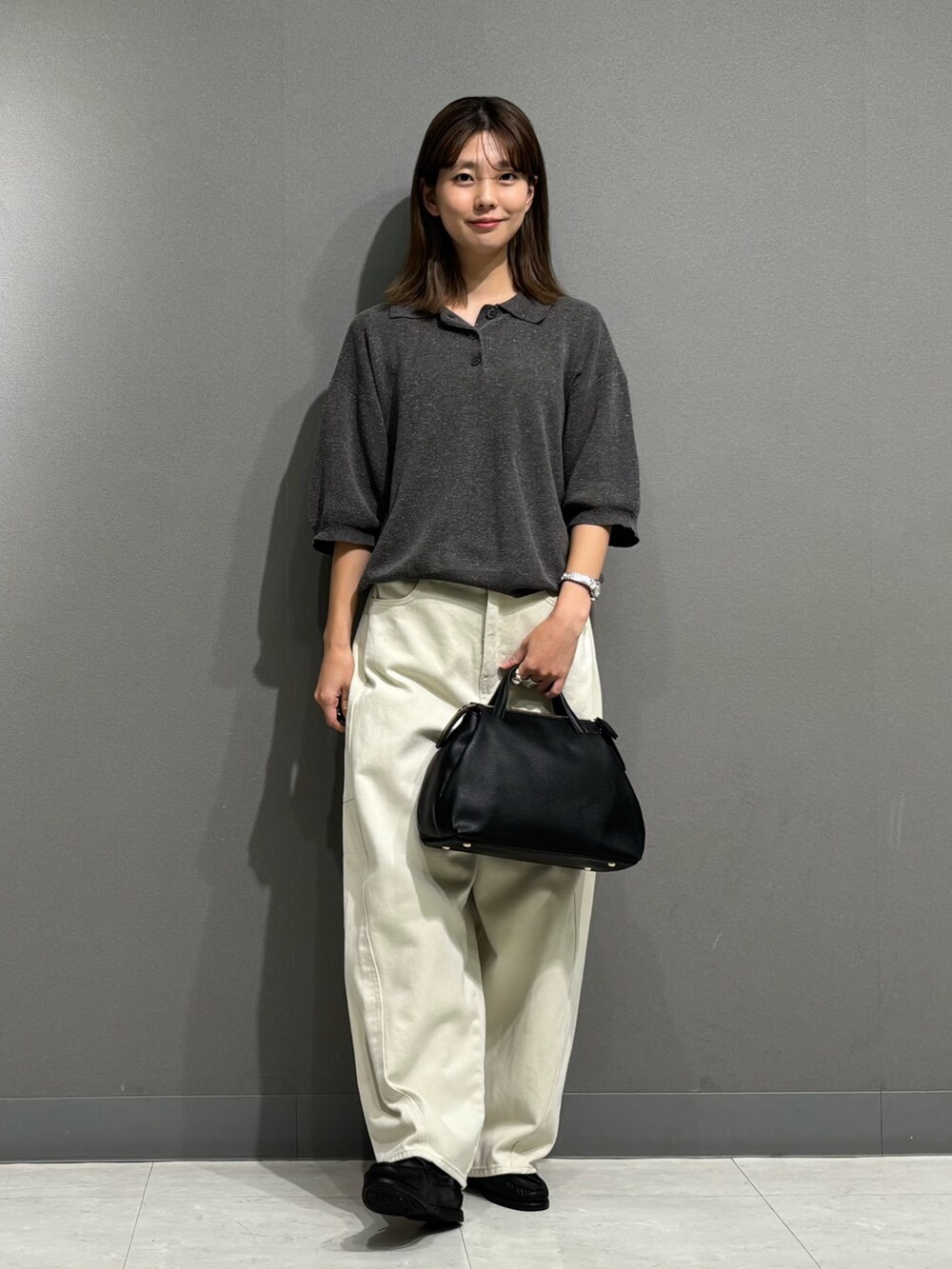 グレー系のポロシャツ、ホワイト系のその他パンツ、ブラック系のトートバッグを着用したレディースの秋コーディネートの4枚目の写真