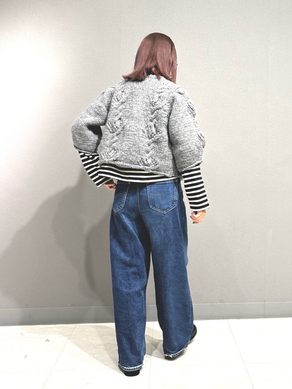 ブルー系のデニムパンツ、グレー系のカーディガン/ボレロ、ブラック系のTシャツ/カットソーを着用したレディースの秋コーディネートの7枚目の写真