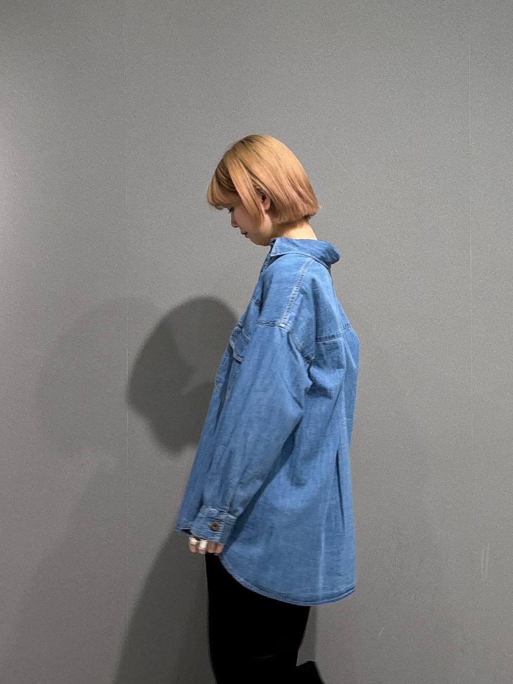 シルバー系のスニーカー、ブルー系のシャツ/ブラウス、ホワイト系のTシャツ/カットソーを着用したレディースの冬コーディネートの3枚目の写真