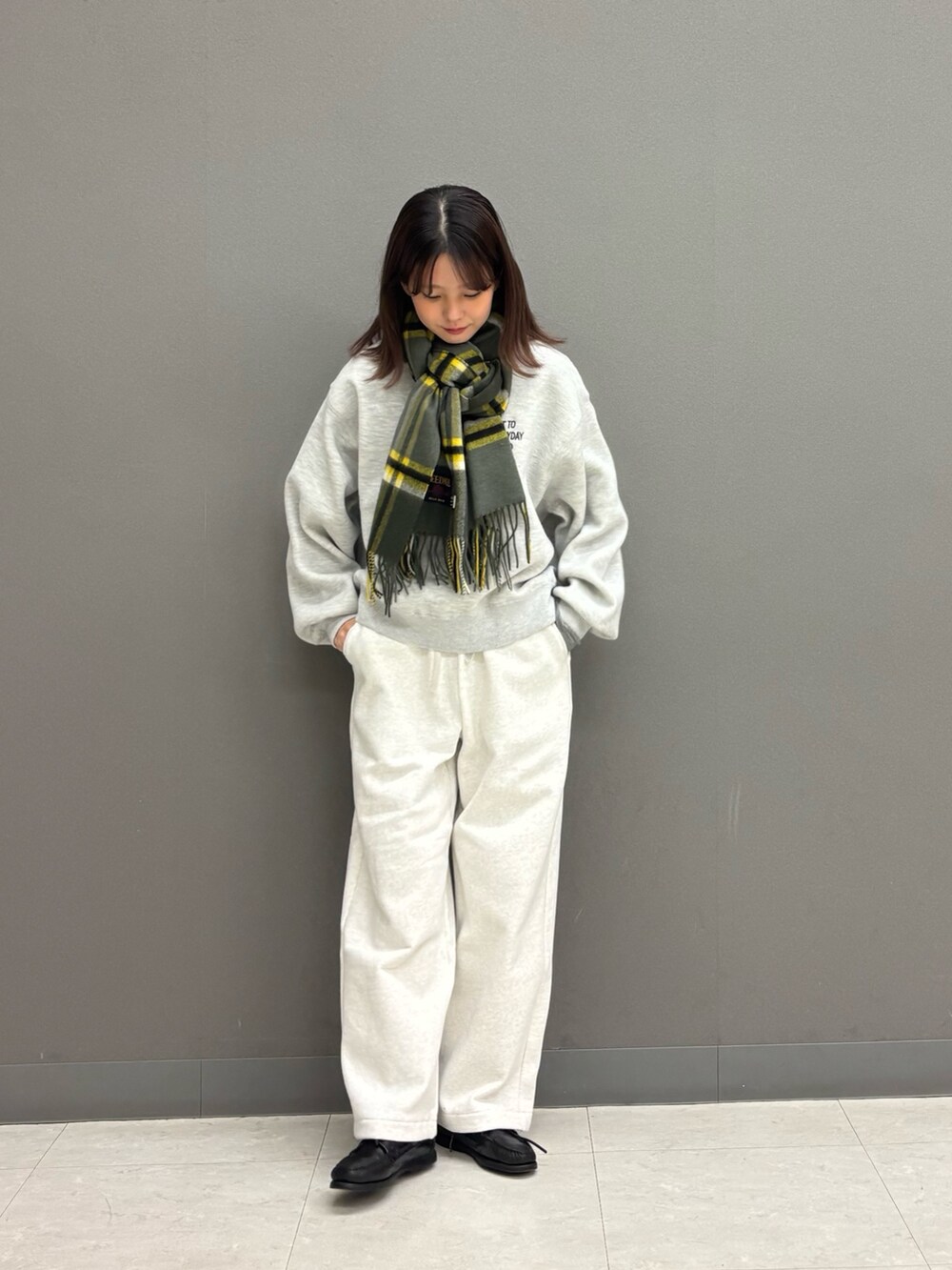 ベージュ系のその他パンツ、グレー系のニット/セーター、ブルー系のダウンジャケット/コートを着用したレディースの秋コーディネートの2枚目の写真