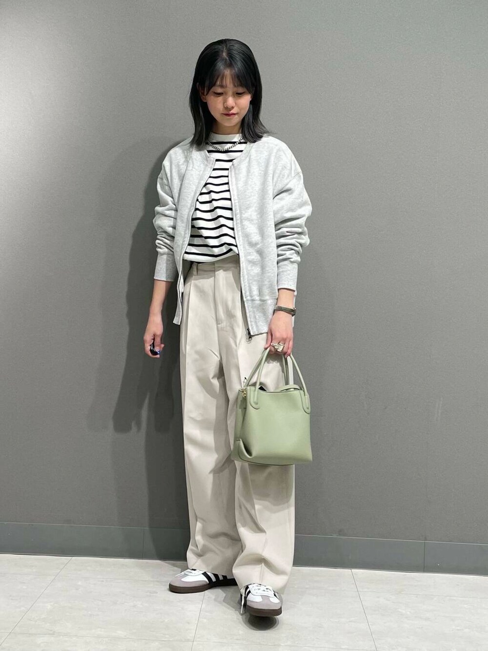 グレー系のカーディガン/ボレロ、グリーン系のショルダーバッグ、ブラック系のTシャツ/カットソーを着用したレディースの春コーディネートの4枚目の写真