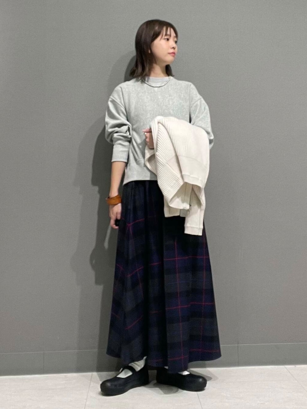 ホワイト系のカーディガン/ボレロ、グレー系のTシャツ/カットソー、ブルー系のスカートを着用したレディースの秋コーディネートの8枚目の写真