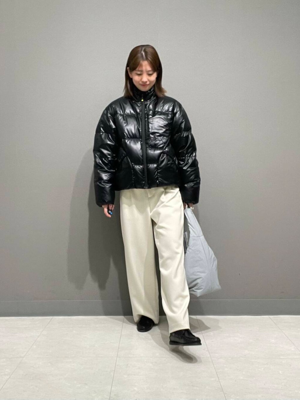 ホワイト系のその他パンツ、ブルー系のTシャツ/カットソー、ブラック系のダウンジャケット/コートを着用したレディースの冬コーディネートの4枚目の写真