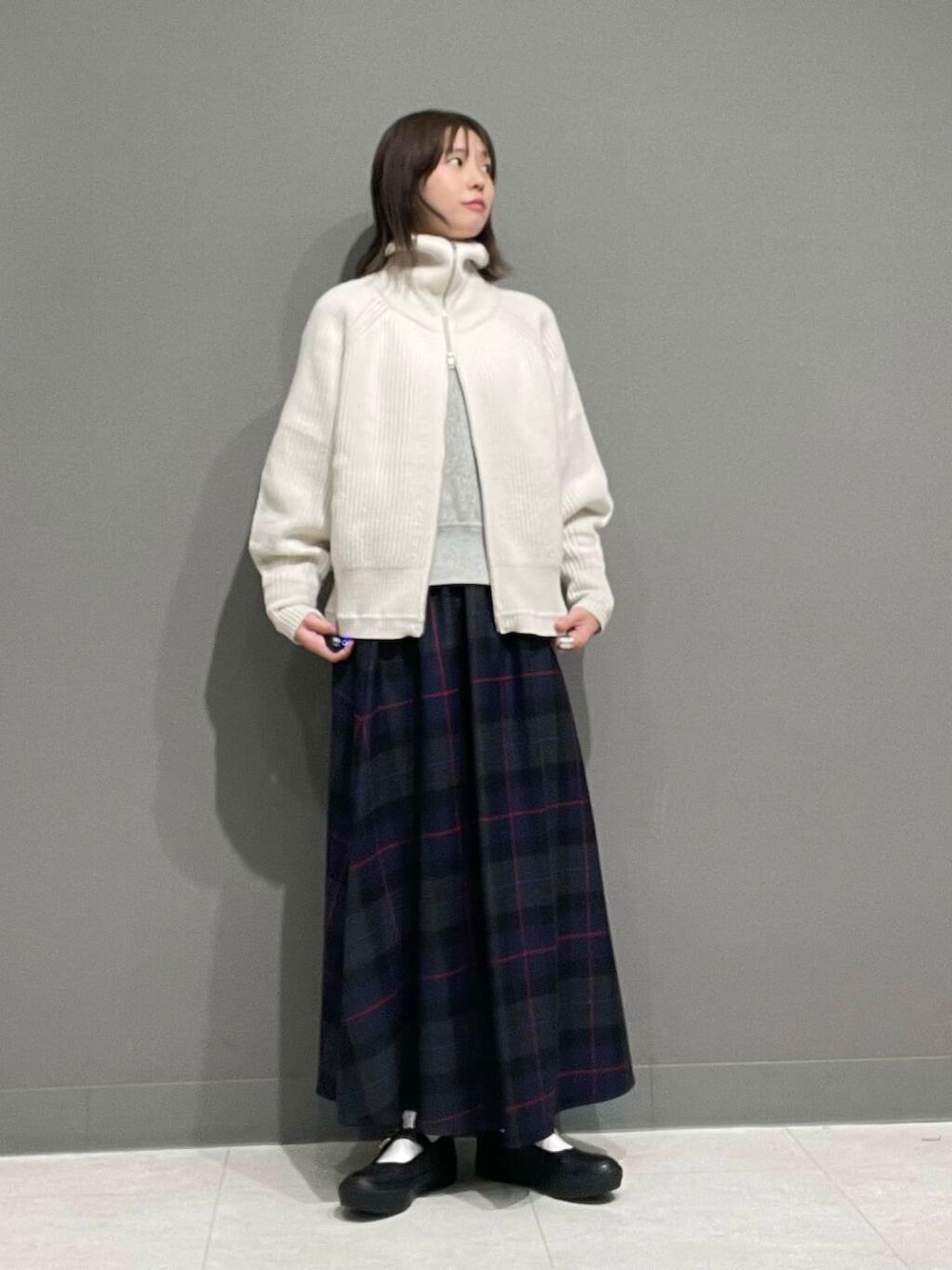 ホワイト系のカーディガン/ボレロ、グレー系のTシャツ/カットソー、ブルー系のスカートを着用したレディースの秋コーディネートの6枚目の写真