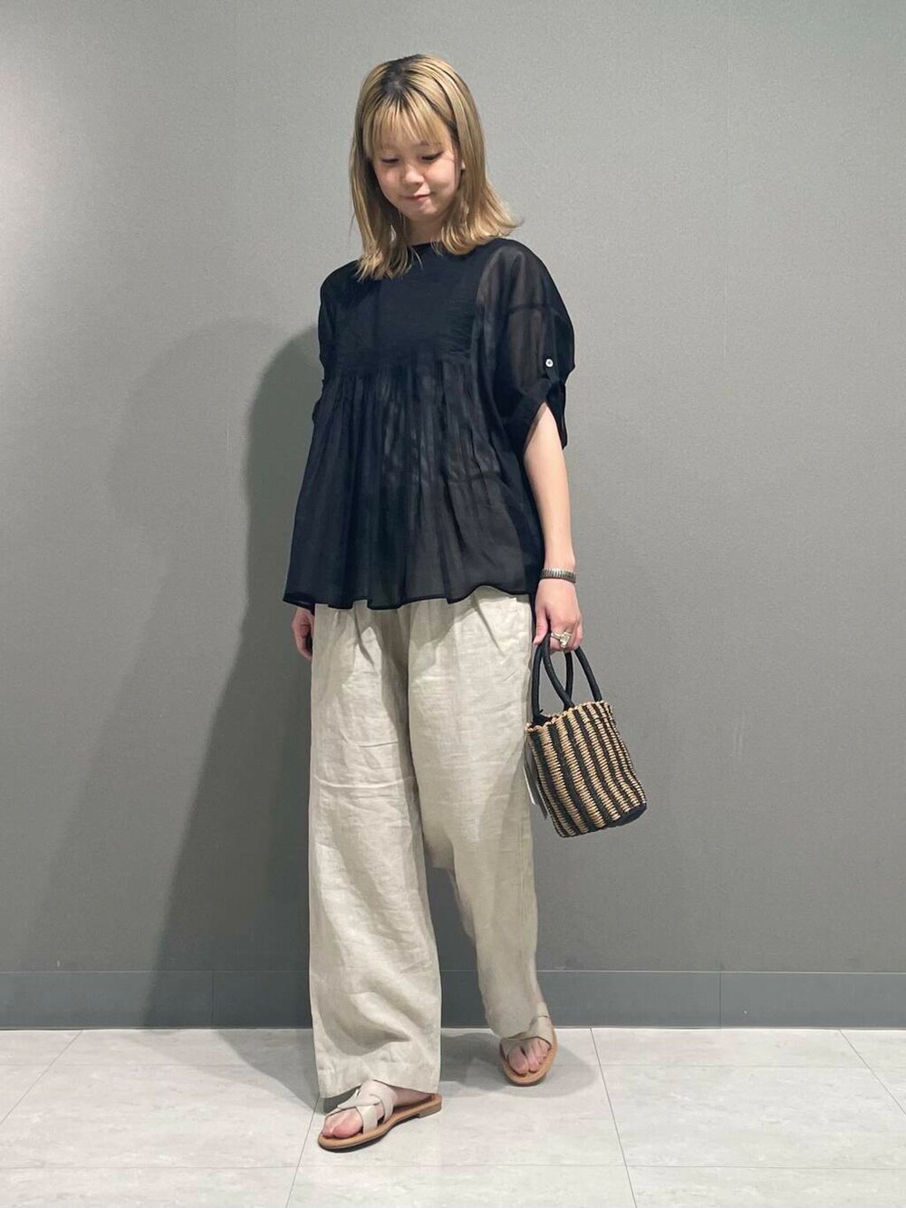 ベージュ系のその他パンツ、ブラック系のハンドバッグ、ブラック系のシャツ/ブラウスを着用したレディースの春コーディネートの2枚目の写真