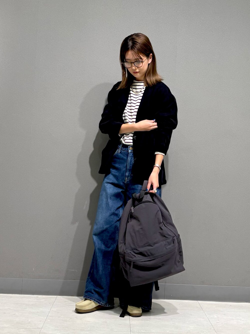 ブラック系のTシャツ/カットソー、ブラック系のノーカラージャケット、グレー系のバックパック/リュックを着用したレディースの秋コーディネートの5枚目の写真