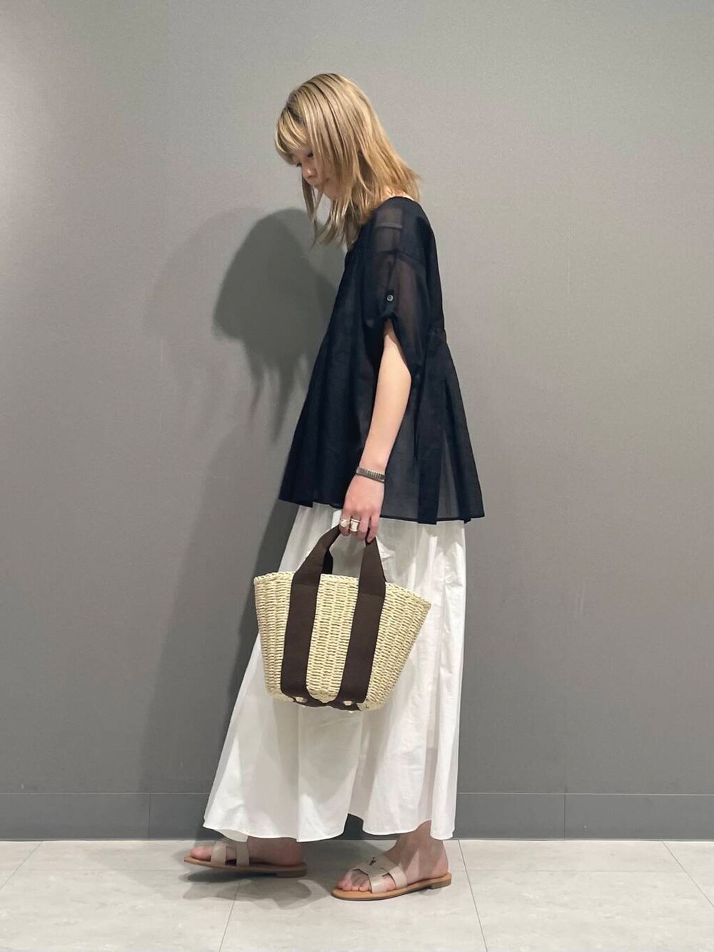 ホワイト系のサンダル、ブラック系のシャツ/ブラウスを着用したレディースの春コーディネートの5枚目の写真