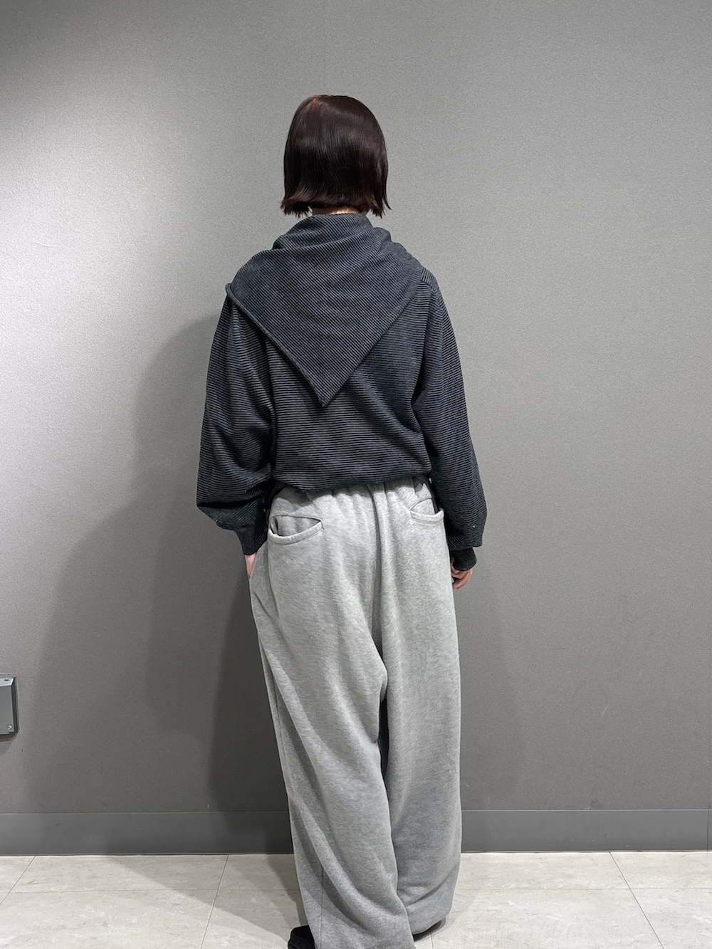 ブラック系のニット/セーター、グレー系のスウェットパンツを着用したレディースの秋コーディネートの6枚目の写真