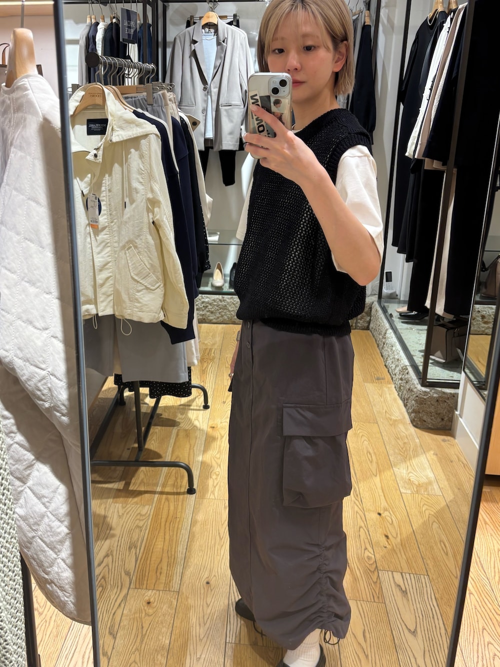 グレー系のTシャツ/カットソー、ブラック系のベスト、グレー系のスカートを着用したレディースの春コーディネートの4枚目の写真