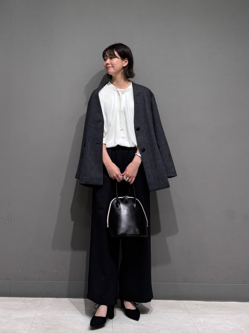 グレー系のノーカラージャケット、ホワイト系のシャツ/ブラウス、ブラック系のその他パンツを着用したレディースの秋コーディネートの2枚目の写真