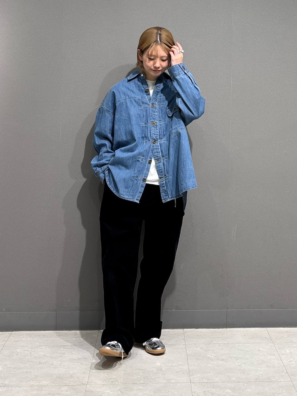 シルバー系のスニーカー、ブルー系のシャツ/ブラウス、ホワイト系のTシャツ/カットソーを着用したレディースの冬コーディネートの2枚目の写真