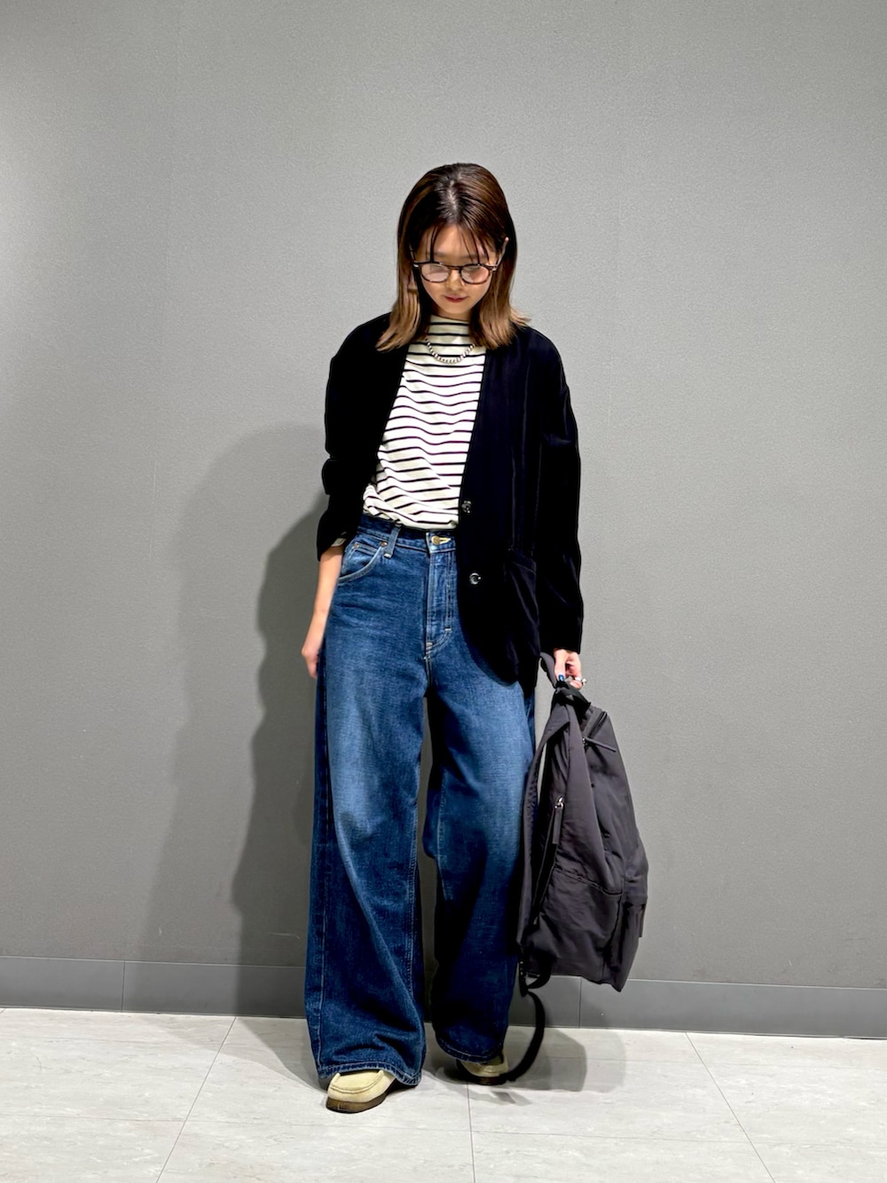 ブラック系のTシャツ/カットソー、ブラック系のノーカラージャケット、グレー系のバックパック/リュックを着用したレディースの秋コーディネートの4枚目の写真