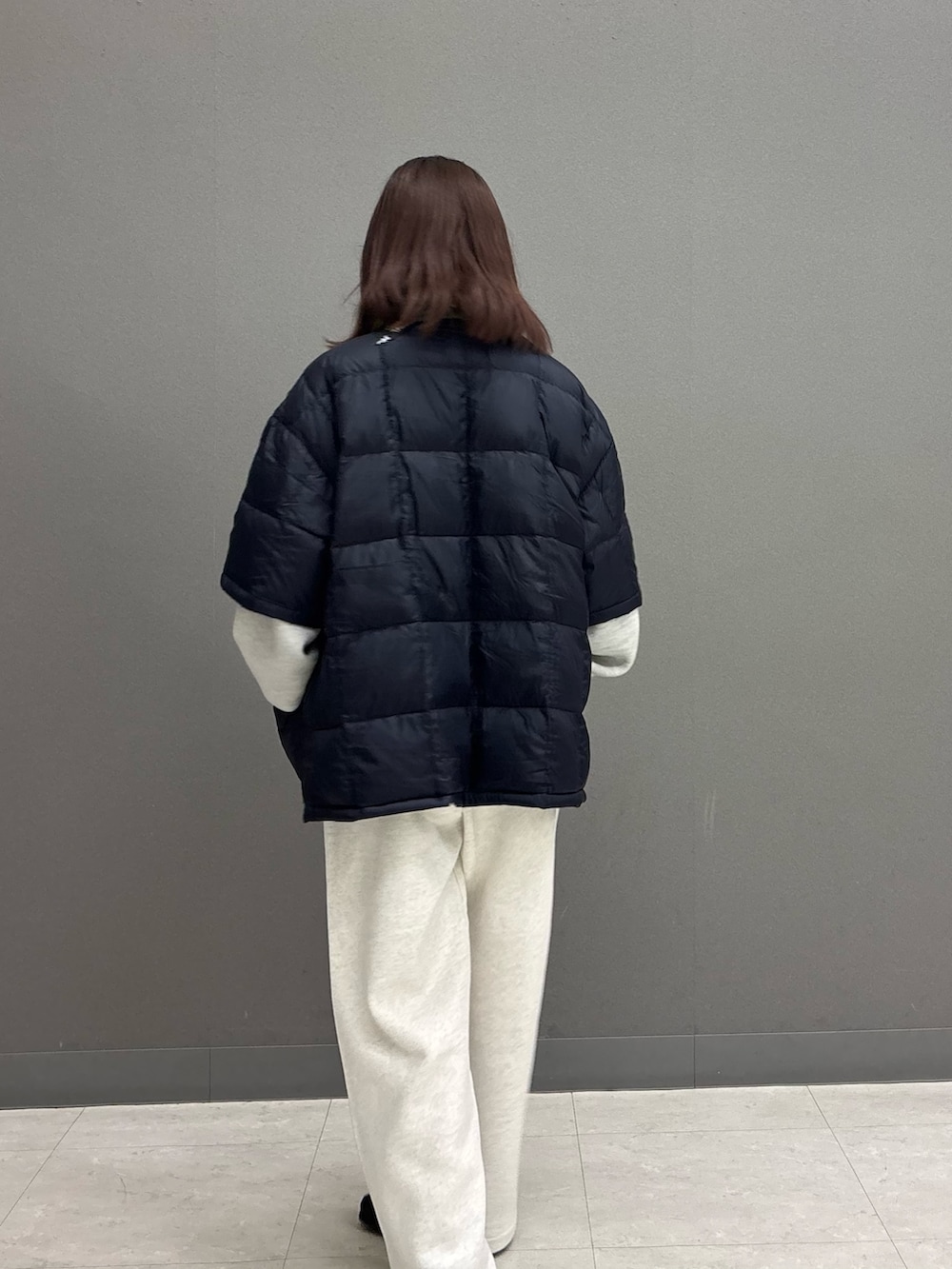 ベージュ系のその他パンツ、グレー系のニット/セーター、ブルー系のダウンジャケット/コートを着用したレディースの秋コーディネートの7枚目の写真