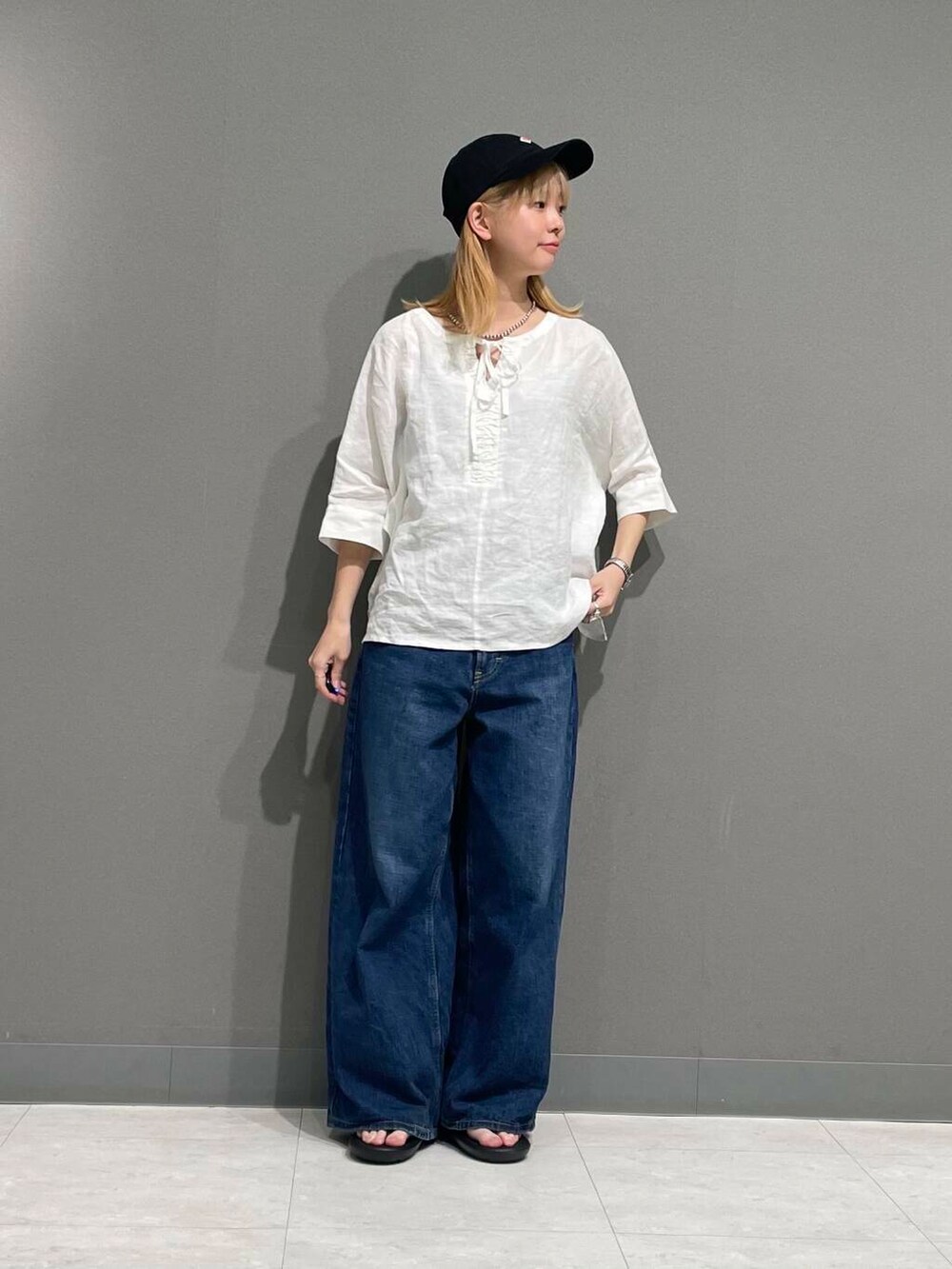 ブルー系のデニムパンツ、ホワイト系のシャツ/ブラウスを着用したレディースの春コーディネートの4枚目の写真