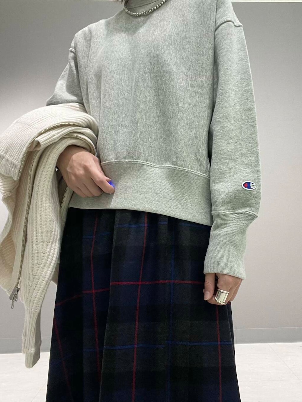 ホワイト系のカーディガン/ボレロ、グレー系のTシャツ/カットソー、ブルー系のスカートを着用したレディースの秋コーディネートの10枚目の写真