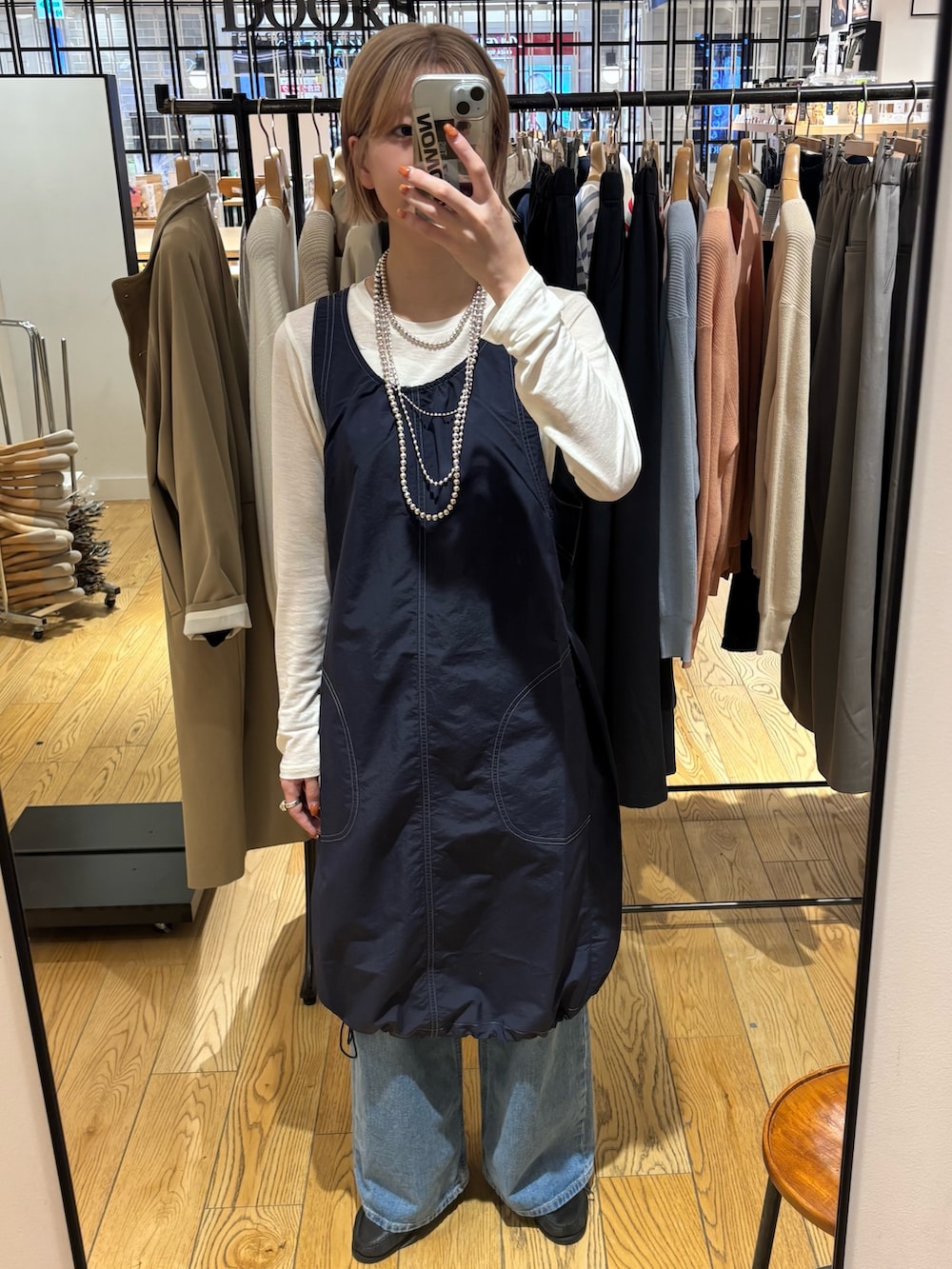 ブルー系のデニムパンツ、ブルー系のワンピース、ホワイト系のTシャツ/カットソーを着用したレディースの春コーディネートの2枚目の写真