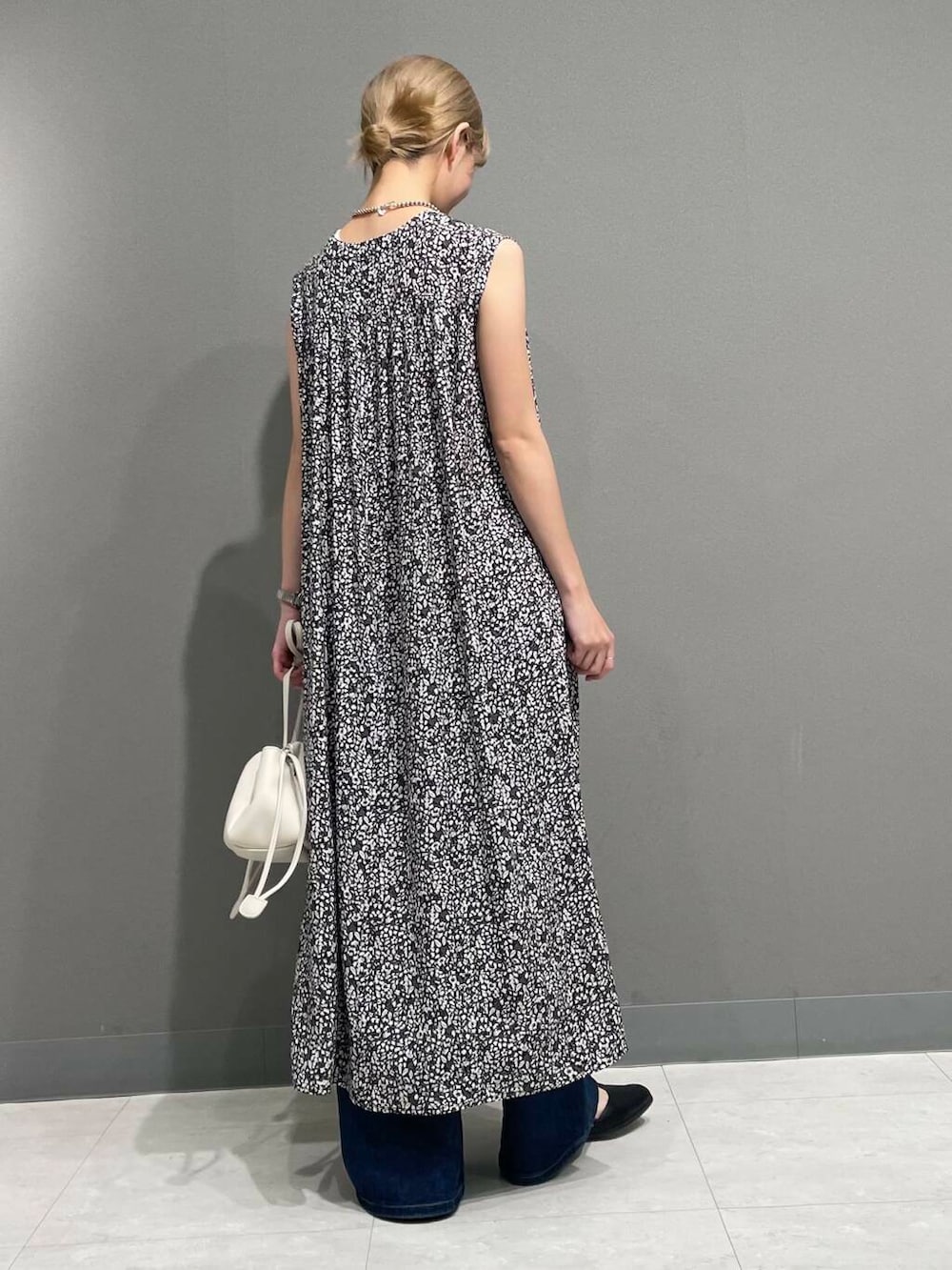 ホワイト系のショルダーバッグ、ブルー系のデニムパンツ、ブラック系のワンピースを着用したレディースの夏コーディネートの4枚目の写真