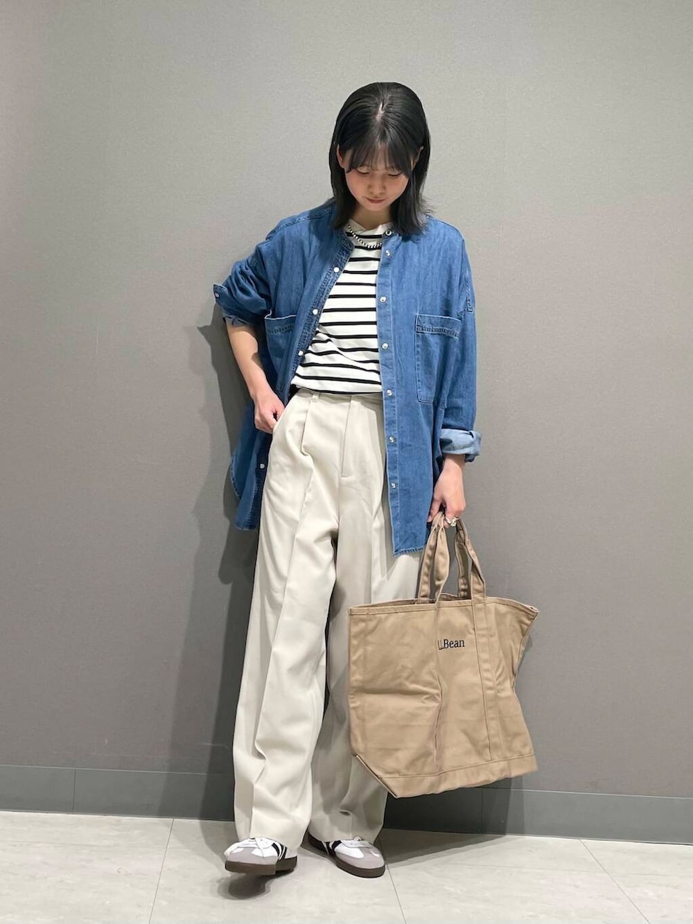 ブルー系のシャツ/ブラウス、ホワイト系のスニーカー、ブラック系のTシャツ/カットソーを着用したレディースの春コーディネートの2枚目の写真