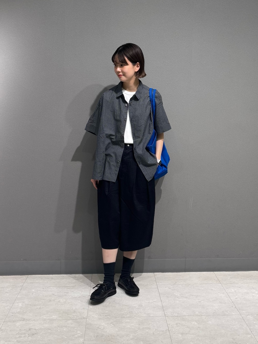 ブルー系のシャツ/ブラウス、ブラック系のその他パンツ、ブルー系のトートバッグを着用したレディースの夏コーディネートの5枚目の写真