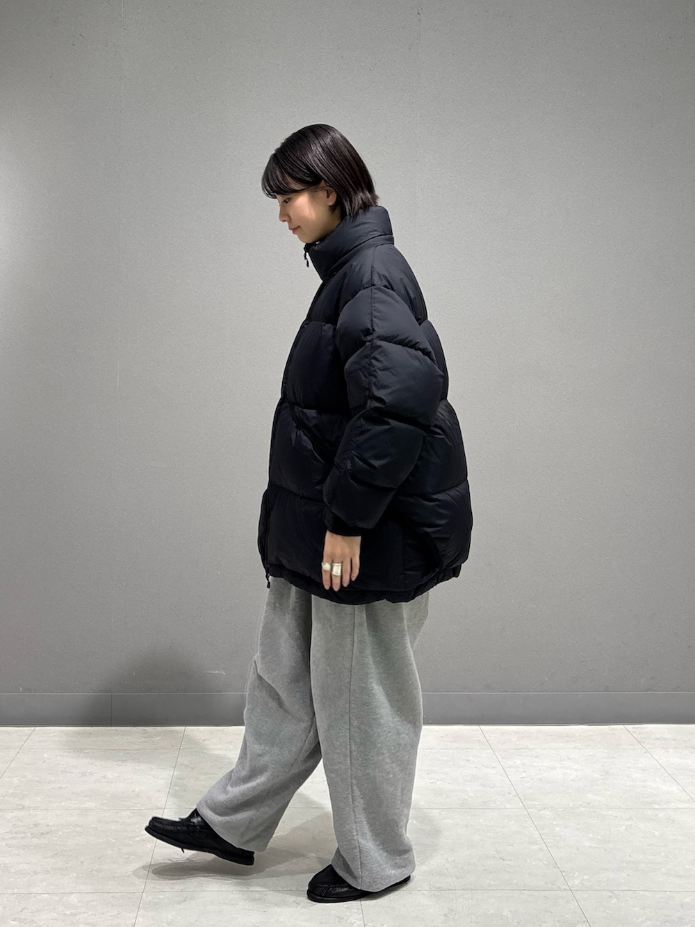 ブラック系のダウンジャケット/コート、グレー系のスウェットパンツを着用したレディースの冬コーディネートの2枚目の写真