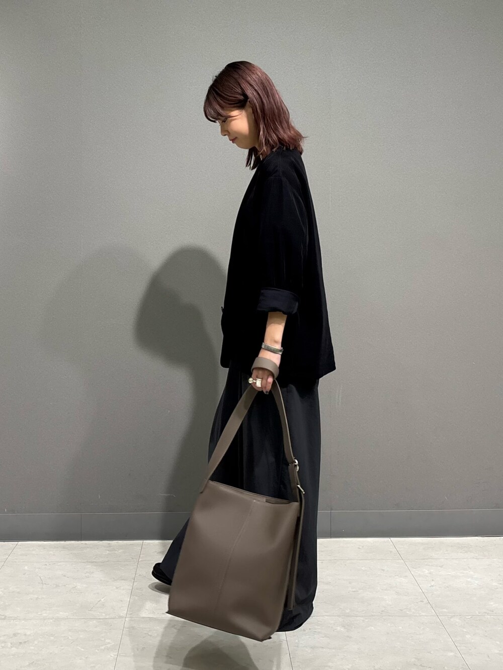 ブラック系のノーカラージャケット、グレー系のショルダーバッグを着用したレディースの秋コーディネートの4枚目の写真