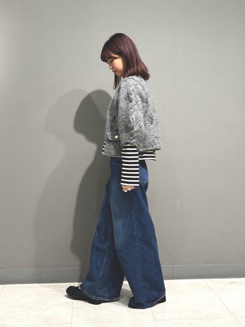 ブルー系のデニムパンツ、グレー系のカーディガン/ボレロ、ブラック系のTシャツ/カットソーを着用したレディースの秋コーディネートの6枚目の写真