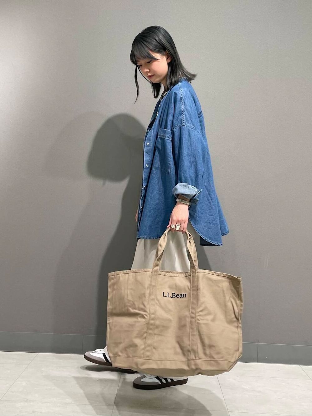 ブルー系のシャツ/ブラウス、ホワイト系のスニーカー、ブラック系のTシャツ/カットソーを着用したレディースの春コーディネートの4枚目の写真