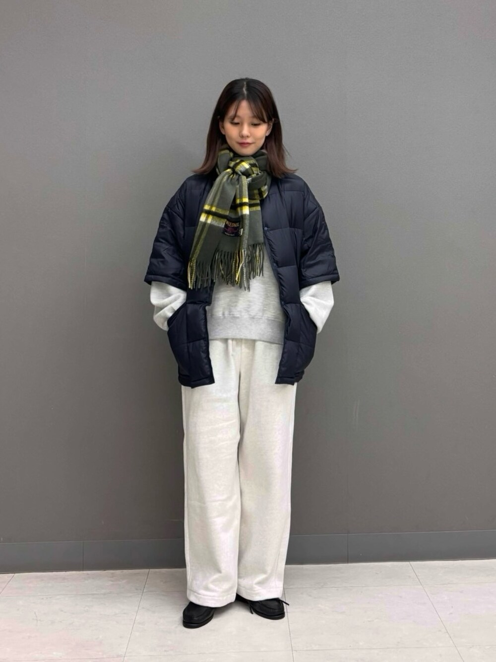 ベージュ系のその他パンツ、グレー系のニット/セーター、ブルー系のダウンジャケット/コートを着用したレディースの秋コーディネートの4枚目の写真