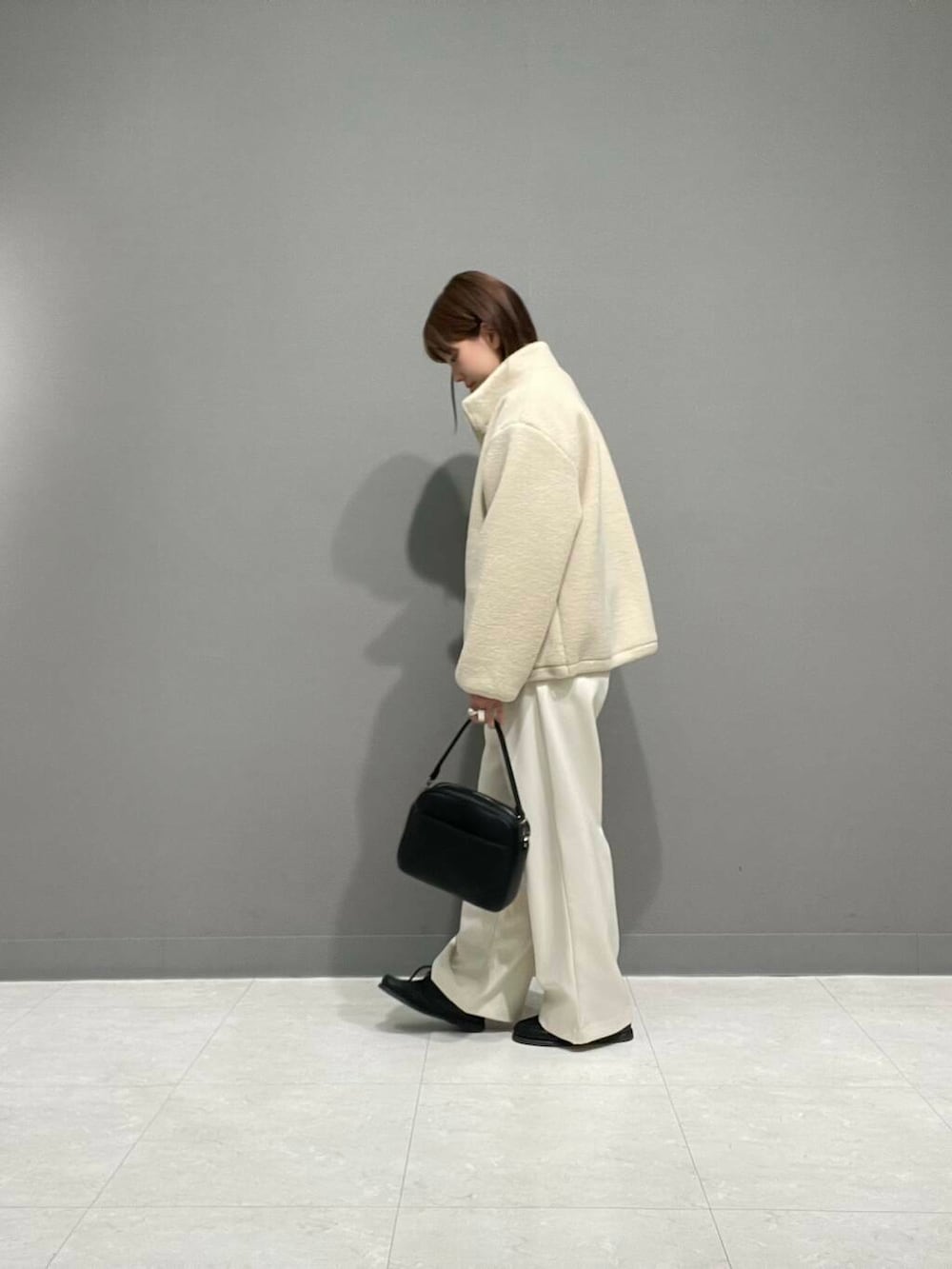 ホワイト系のその他パンツ、ホワイト系のブルゾン、ブルー系のTシャツ/カットソーを着用したレディースの冬コーディネートの3枚目の写真