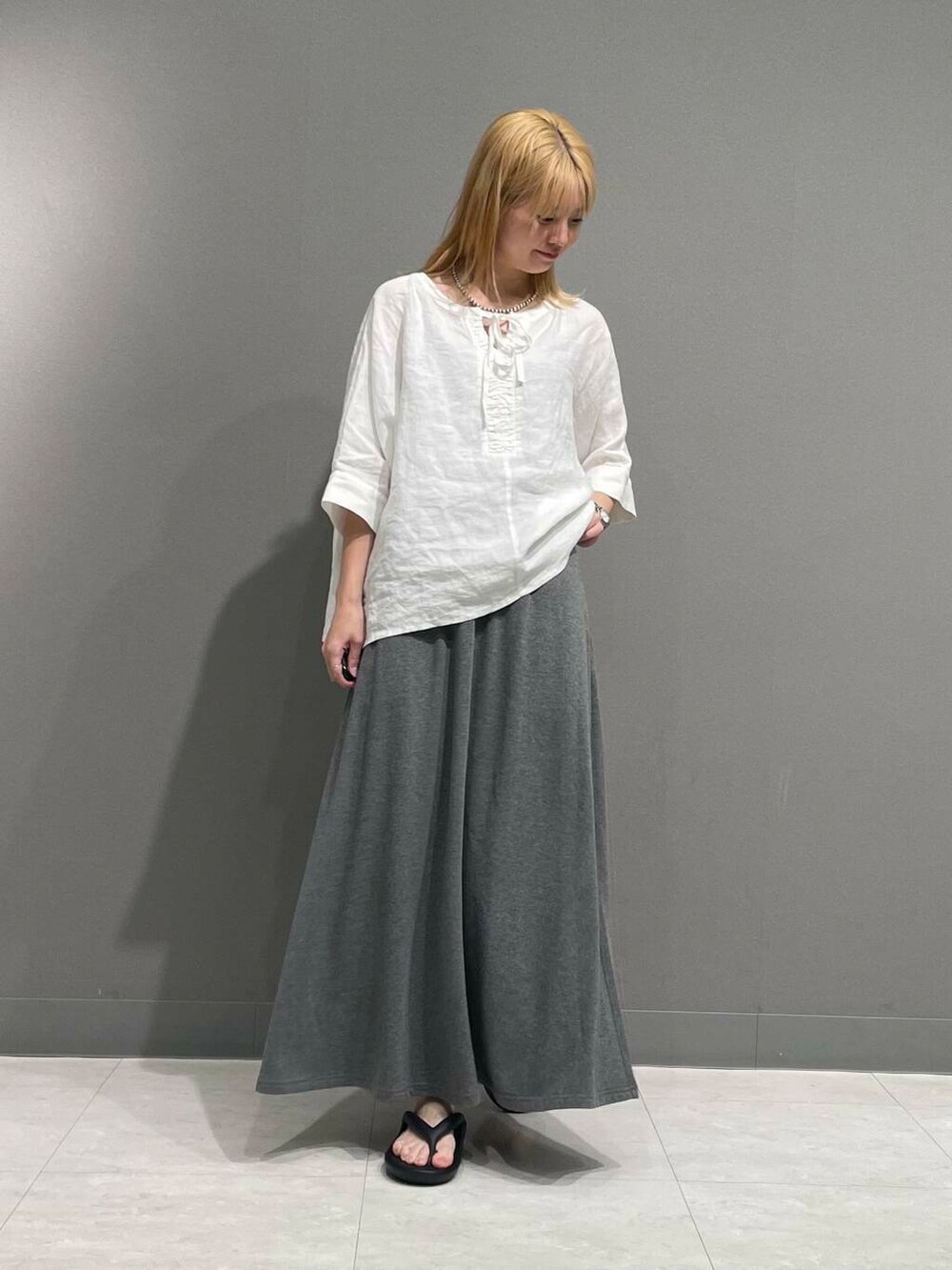 グレー系のスカート、ホワイト系のシャツ/ブラウスを着用したレディースの春コーディネートの2枚目の写真
