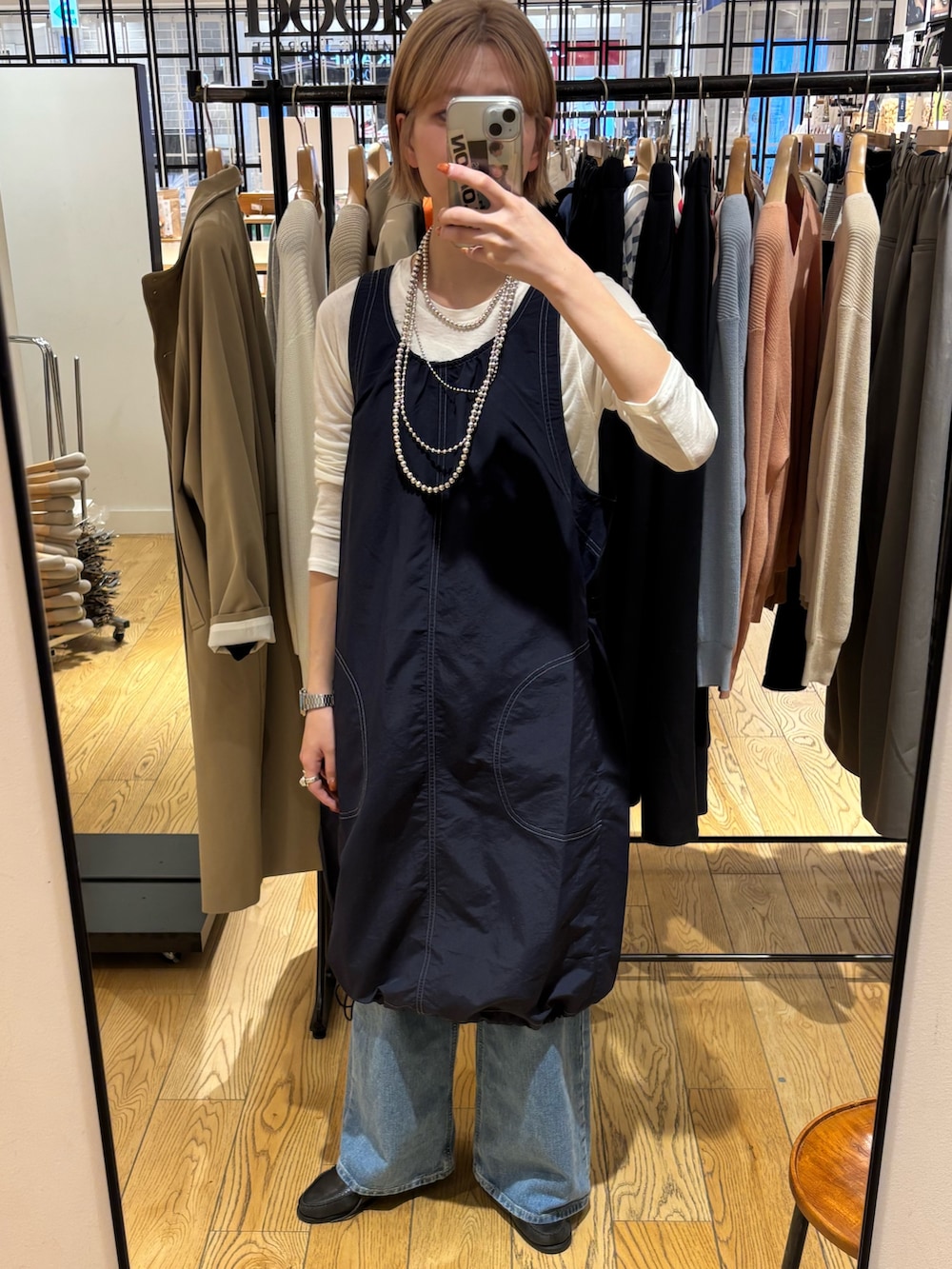 ブルー系のデニムパンツ、ブルー系のワンピース、ホワイト系のTシャツ/カットソーを着用したレディースの春コーディネートの5枚目の写真