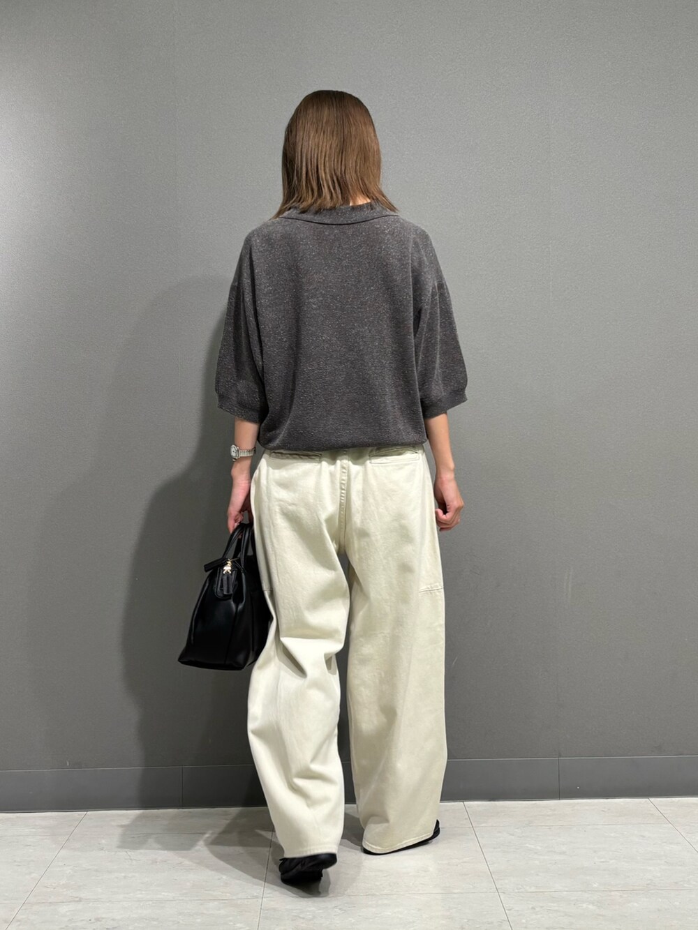 グレー系のポロシャツ、ホワイト系のその他パンツ、ブラック系のトートバッグを着用したレディースの秋コーディネートの3枚目の写真