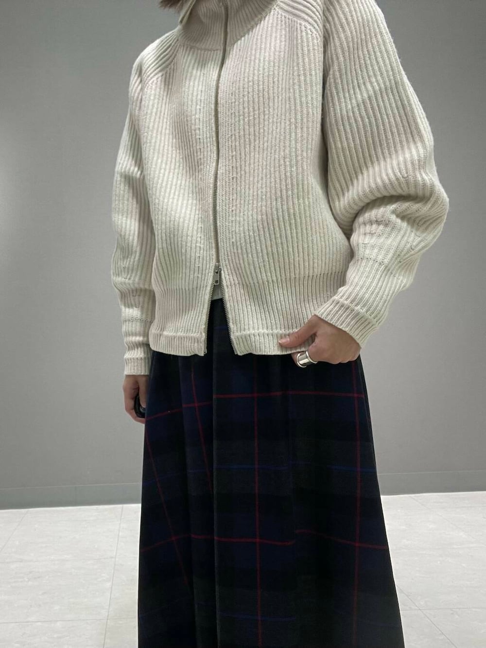 ホワイト系のカーディガン/ボレロ、グレー系のTシャツ/カットソー、ブルー系のスカートを着用したレディースの秋コーディネートの5枚目の写真