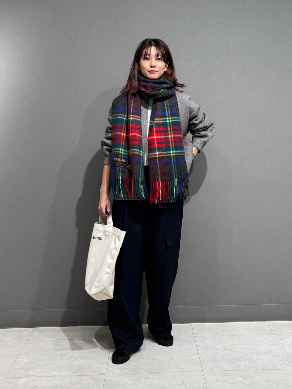 グレー系のその他パンツ、グリーン系のニット/セーター、ベージュ系のショルダーバッグを着用したレディースの秋コーディネートの2枚目の写真