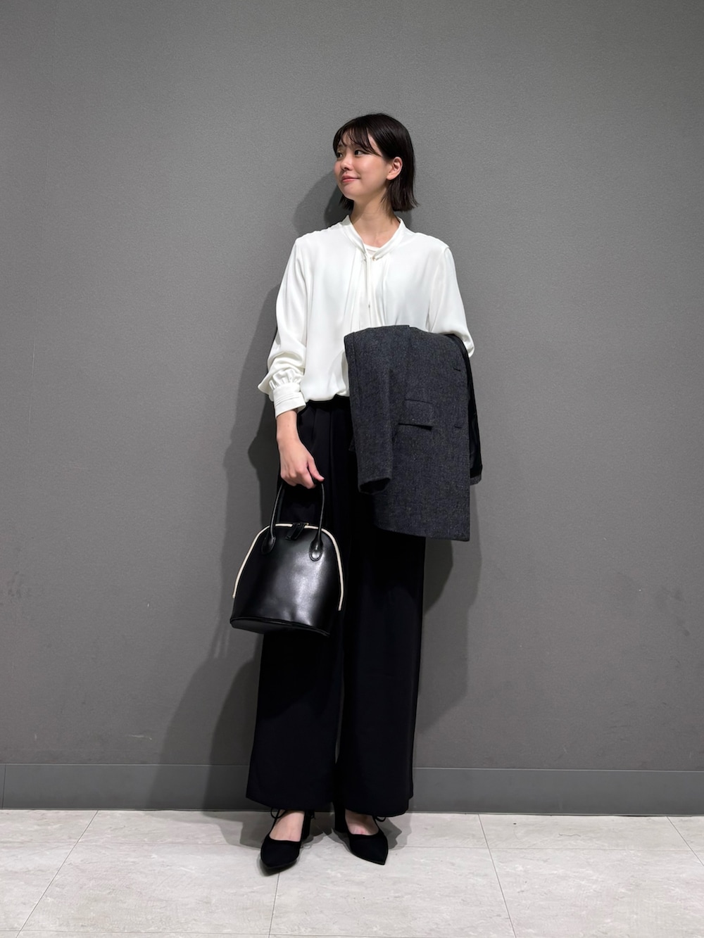 グレー系のノーカラージャケット、ホワイト系のシャツ/ブラウス、ブラック系のその他パンツを着用したレディースの秋コーディネートの3枚目の写真