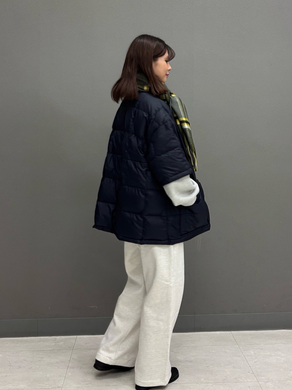 ベージュ系のその他パンツ、グレー系のニット/セーター、ブルー系のダウンジャケット/コートを着用したレディースの秋コーディネートの6枚目の写真