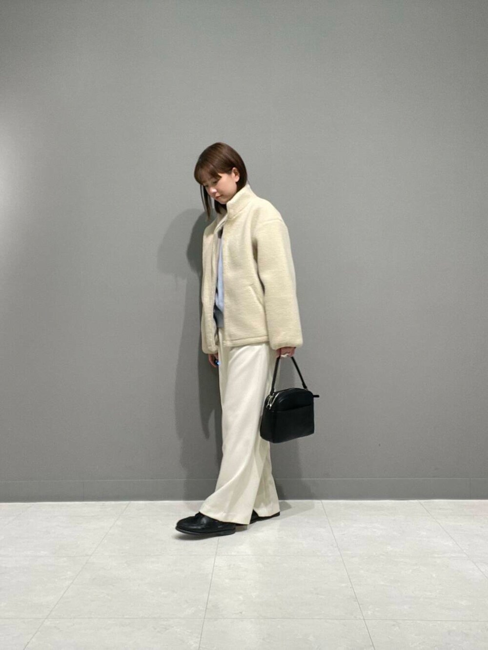 ホワイト系のその他パンツ、ホワイト系のブルゾン、ブルー系のTシャツ/カットソーを着用したレディースの冬コーディネートの4枚目の写真