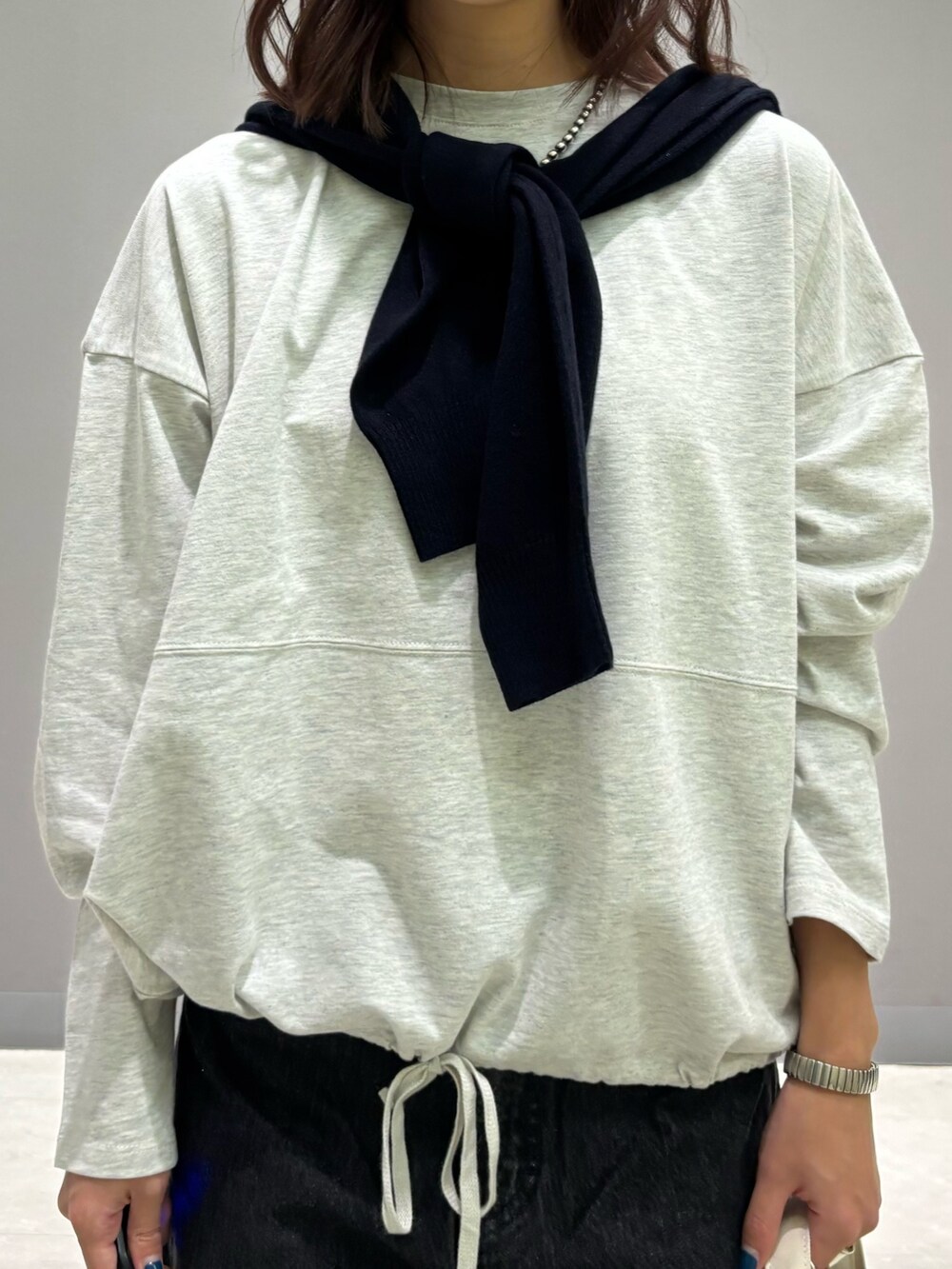 ベージュ系のTシャツ/カットソー、ブルー系のカーディガン/ボレロ、ブラック系のデニムパンツを着用したレディースの秋コーディネートの8枚目の写真