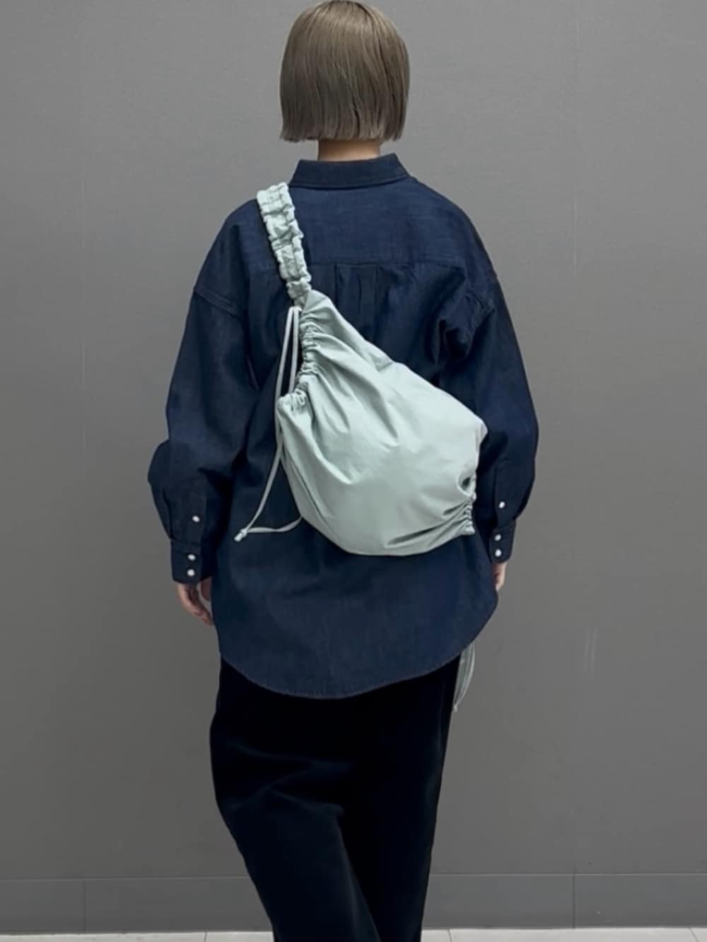 ブルー系のショルダーバッグ、ブルー系のシャツ/ブラウスを着用したレディースの冬コーディネートの2枚目の写真