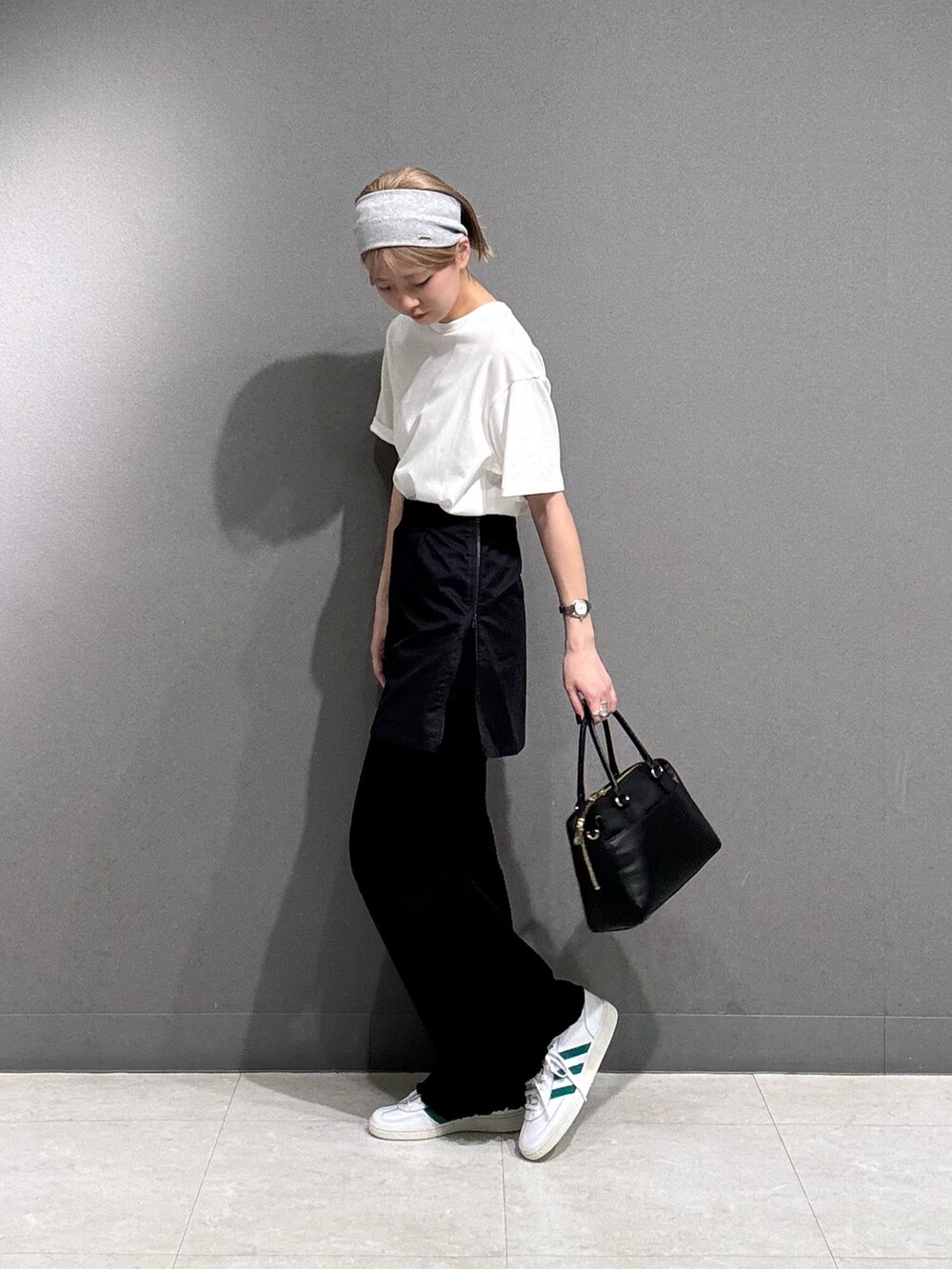 ブラック系のその他パンツ、ホワイト系のTシャツ/カットソー、ホワイト系のスニーカーを着用したレディースの春コーディネートの4枚目の写真