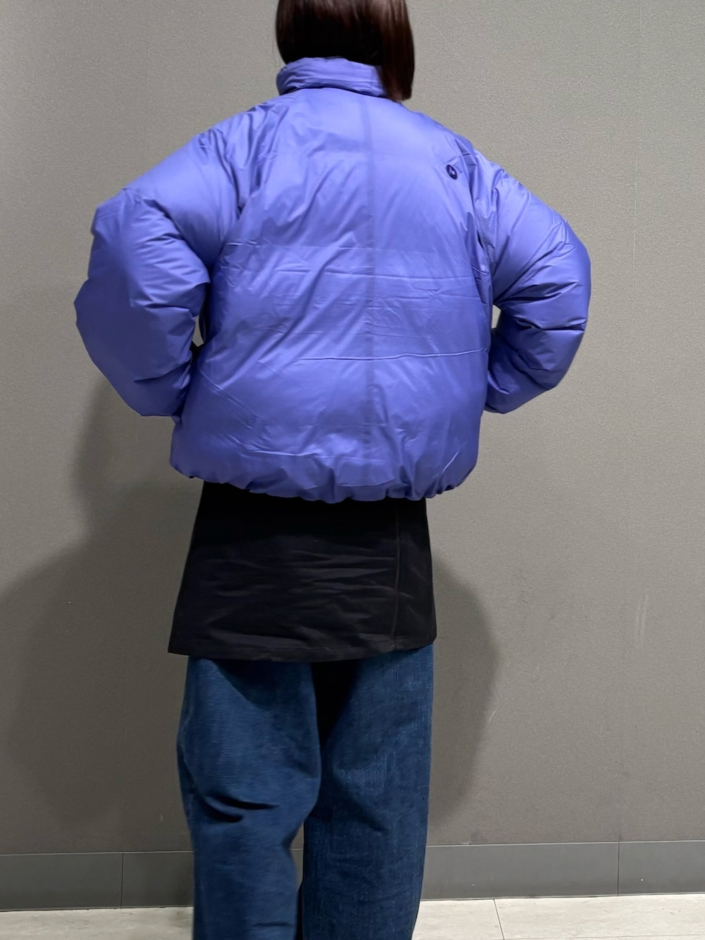 パープル系のダウンジャケット/コート、ブルー系のデニムパンツ、ベージュ系のサンダルを着用したレディースの秋コーディネートの5枚目の写真