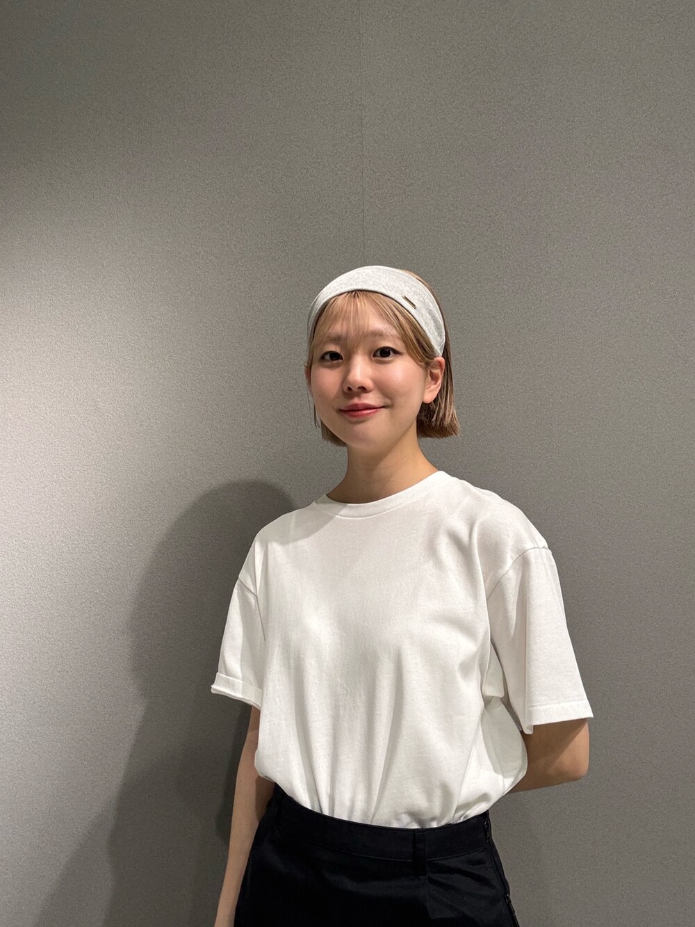 ブラック系のその他パンツ、ホワイト系のTシャツ/カットソー、ホワイト系のスニーカーを着用したレディースの春コーディネートの6枚目の写真