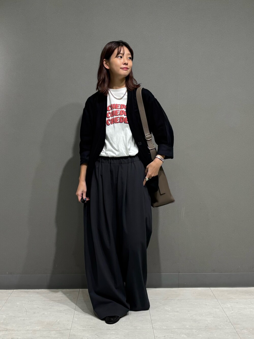 ブラック系のノーカラージャケット、グレー系のショルダーバッグを着用したレディースの秋コーディネートの2枚目の写真