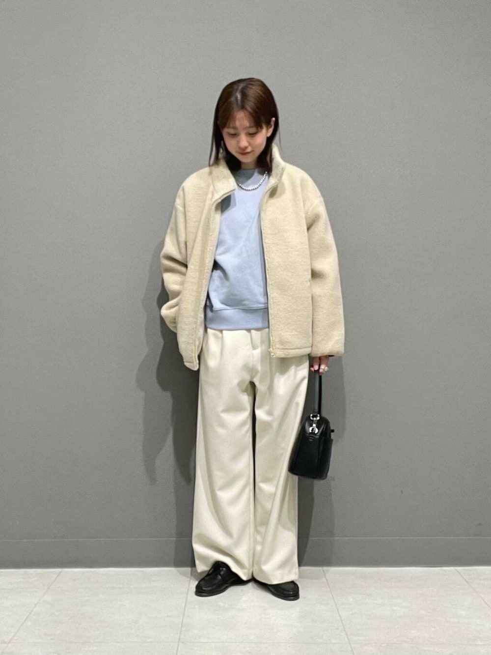 ホワイト系のその他パンツ、ホワイト系のブルゾン、ブルー系のTシャツ/カットソーを着用したレディースの冬コーディネートの2枚目の写真