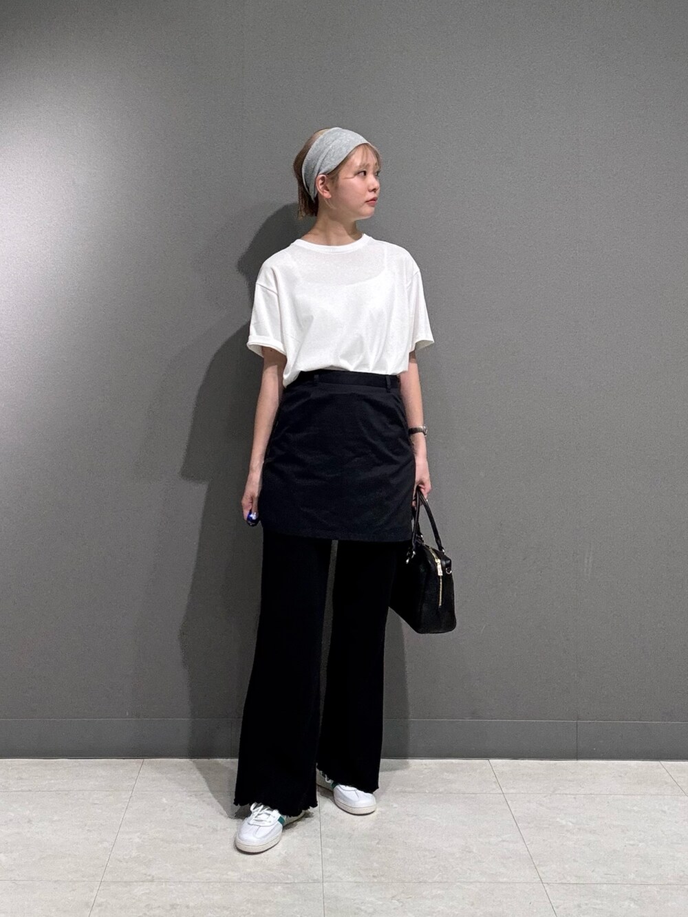 ブラック系のその他パンツ、ホワイト系のTシャツ/カットソー、ホワイト系のスニーカーを着用したレディースの春コーディネートの3枚目の写真