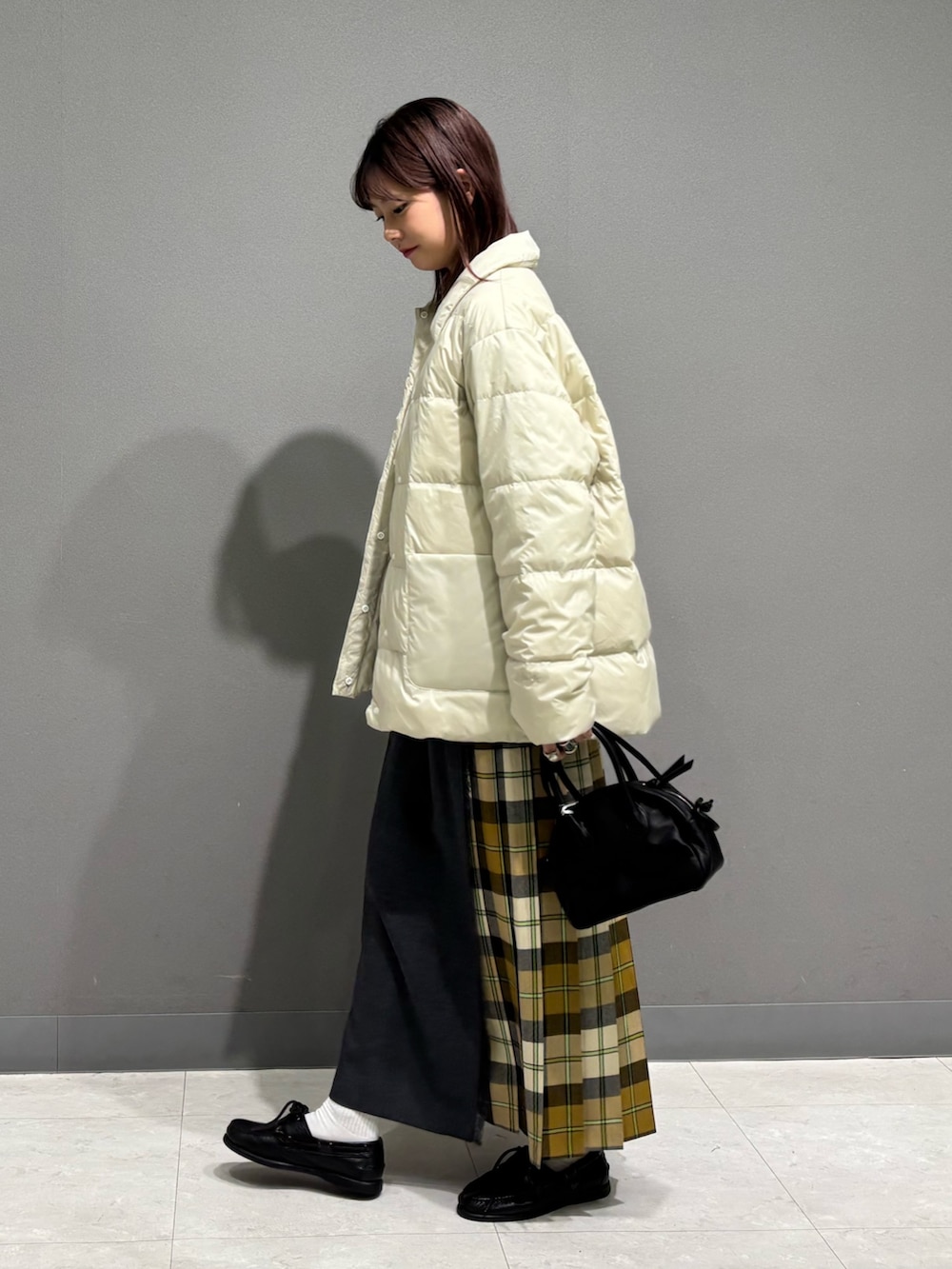 ホワイト系のダウンジャケット/コート、ホワイト系のニット/セーター、ベージュ系のスカートを着用したレディースの秋コーディネートの3枚目の写真